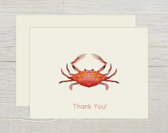 May include: Two cream-colored greeting cards with a watercolor illustration of a red crab. The crab is centered on the card and the text "Thank You!" is printed in a dark red font below the crab.