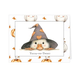 Pu&ograve; includere: Biglietto di auguri di Halloween con un'anatra che indossa un cappello da strega grigio con cuori arancioni. Il biglietto &egrave; decorato con illustrazioni di zucche e foglie. Il testo "Trick-or-Tweet" &egrave; stampato sul biglietto.