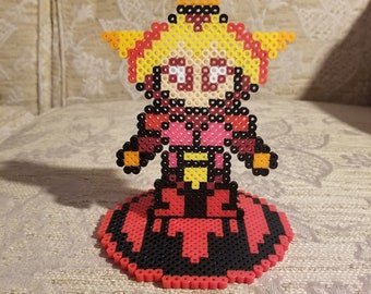 May include: A red, yellow, and black pixel art figure of a character with a star on their head standing on a red and black circular base.