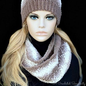 May include: A brown and white striped crocheted hat with a faux fur pom pom and matching infinity scarf.