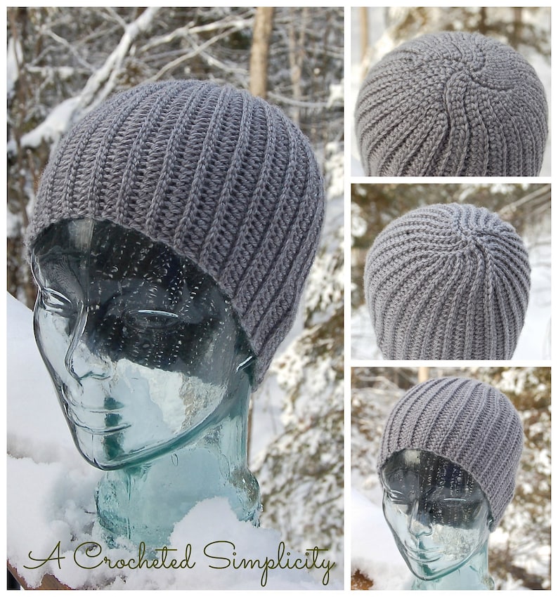 K&ouml;nnte beinhalten: Graue H&auml;kelm&uuml;tze auf einem Glas-Mannequin-Kopf. Die M&uuml;tze ist gerippt und hat ein schlichtes Design. Die M&uuml;tze ist vor einem verschneiten Hintergrund fotografiert.