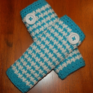 May include: A pair of blue and white crocheted arm warmers with white buttons.