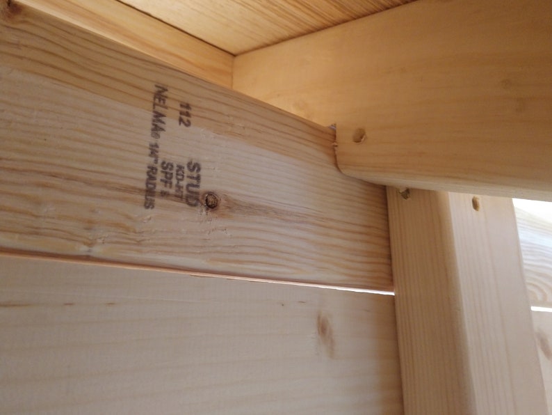 May include: Close-up of a wooden stud with the text "STUD KD-HT 40/4" and "112 NELMA 1 1/4" SPF" printed on it.