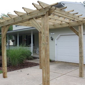 May include: A wooden pergola with a lattice top, providing shade and a decorative element for a home's exterior.