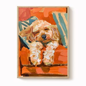 May include: Oil painting of a sleeping dog with light brown fur, resting on an orange surface. The dog is lying on a striped pillow with blue and green stripes. The artwork is framed in a light wood frame.