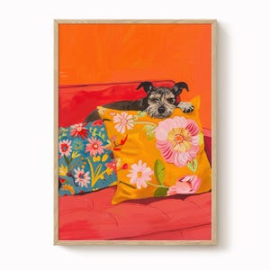 Könnte beinhalten: Gerahmter Kunstdruck mit einem kleinen Hund, der auf einem roten Sofa mit Blumenkissen ruht. Der Hund hat schwarz-graues Fell. Ein Kissen ist gelb mit rosa Blumen, das andere blau mit weißen und rosa Blumen. Der Hintergrund ist orange.