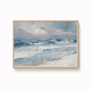 Könnte beinhalten: Aquarellmalerei eines Meereslandschaftsbildes mit Holzrahmen. Das Kunstwerk zeigt Ozeanwellen in Blau- und Weißtönen, die sich an einem sandigen Ufer unter einem bewölkten Himmel brechen. Das Gemälde vermittelt ein Gefühl von Ruhe und natürlicher Schönheit.