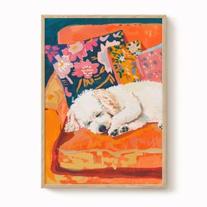 Pode incluir: Impressão artística emoldurada de um cão branco a dormir numa almofada laranja. O cão repousa sobre uma disposição colorida de almofadas com padrões florais e abstratos. A obra de arte tem uma paleta de cores quente e convidativa.