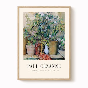 May include: A framed print of a still life painting by Paul Cézanne, featuring terracotta pots and flowers. The artwork displays a variety of green foliage, white flowers, and a red and orange patterned cloth. A small white pitcher is also visible.