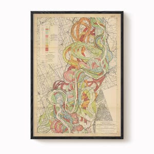 May include: Framed vintage map print featuring a colorful geological illustration of a river system. The map displays a network of lines and colorful, winding patterns in shades of red, orange, green, and blue. The map is framed in a black wooden frame.