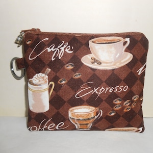 May include: A brown zippered pouch with a coffee theme. The pouch has a brown and white checkered pattern with coffee cups, coffee beans, and the words "Caffe", "Espresso", and "Coffee".