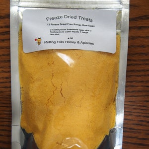 May include: A silver resealable pouch containing a yellow powder labeled "Freeze Dried Treats 12 Freeze Dried Free Range Raw Eggs 2 Tablespoons Powdered eggs plus 2 Tablespoons water equals 1 Large raw egg. 4 OZ Rolling Hills Honey & Apiaries"