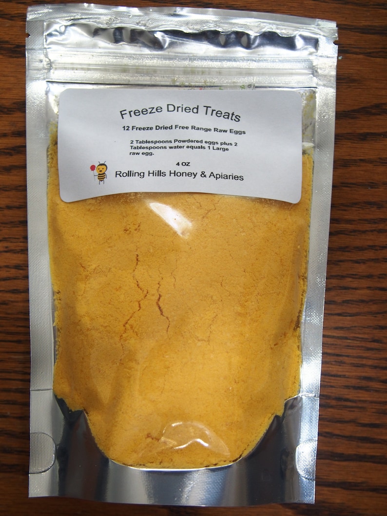 May include: A silver resealable pouch containing a yellow powder labeled "Freeze Dried Treats 12 Freeze Dried Free Range Raw Eggs 2 Tablespoons Powdered eggs plus 2 Tablespoons water equals 1 Large raw egg. 4 OZ Rolling Hills Honey & Apiaries"
