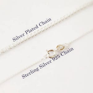 Puede incluir: Dos cadenas de plata, una etiquetada como "Cadena plateada" y la otra como "Cadena de plata de ley 925".