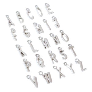 May include: Silver alphabet letter charms, each letter is separate and has a jump ring for attaching to a necklace, bracelet, or other jewellery project.