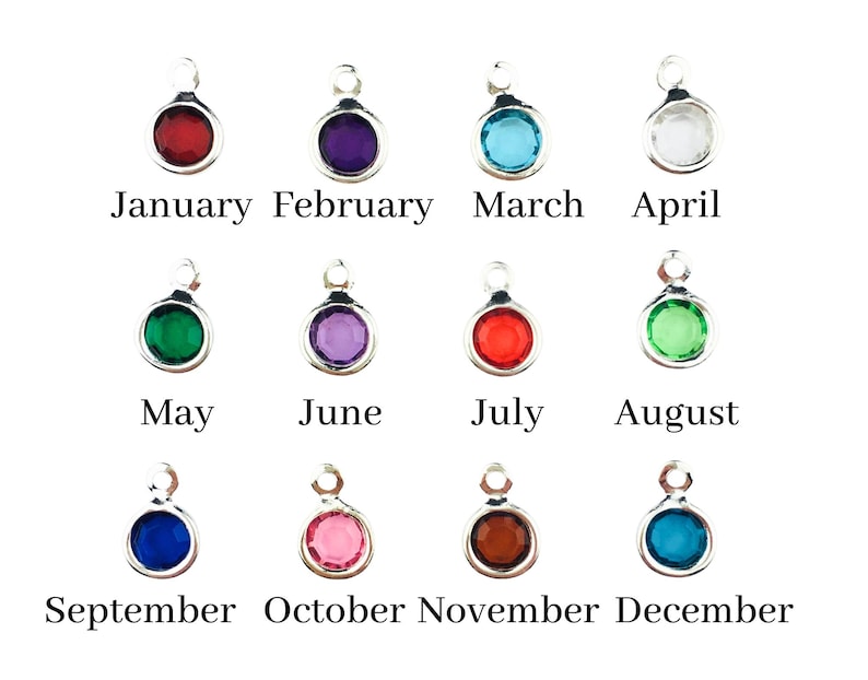 May include: Twelve circular silver-toned charms, each featuring a different coloured gemstone representing a month of the year. The charms are labelled with the corresponding months from January to December in black text below each individual piece.