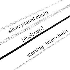 Op de afbeelding: Drie verschillende soorten kettingen: een zilveren ketting, een zwart koord en een sterling zilveren ketting.