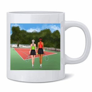 May include: White ceramic mug with a colorful illustration of two women playing tennis on a green court. The women are wearing colorful athletic wear and holding tennis rackets.