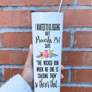 May include: White tumbler with a black lid and a straw. The tumbler has a floral design and text that reads "I wanted to go jogging but Proverbs 28:1 says "The wicked run when no one is chasing them" so there's that..."