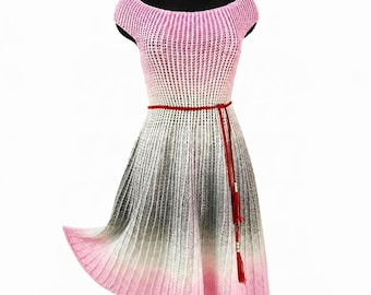 Puede incluir: Un vestido de punto con escote barco y textura acanalada. La prenda presenta un patrón de color degradado que transiciona de rosa en la parte superior a blanco, gris y de vuelta a rosa en el dobladillo. Un cinturón de cordón rojo está atado a la cintura.