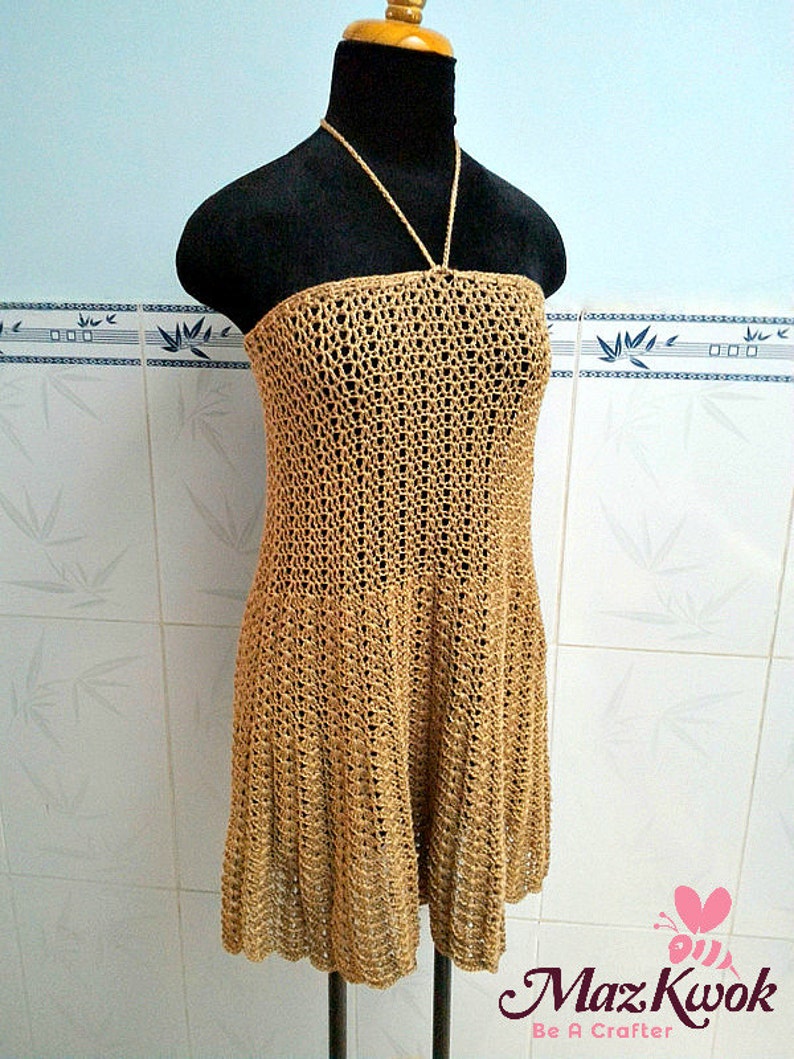 May include: A brown crochet halter dress with a loose fit and a scalloped hem.