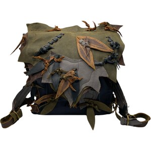May include: A dark green, blue, and brown leather backpack with a unique design featuring multiple leather leaves and straps.