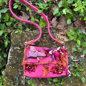 Paleta de colores rosa y naranja personalizada con polilla, gemas, flecos y lazos para adaptarse al iPad de 11”.