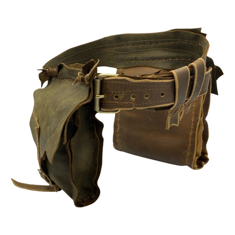 Op de afbeelding: Een bruine leren gereedschapsriem met meerdere zakken en een messing gesp. De riem is versleten en heeft een verweerde look.