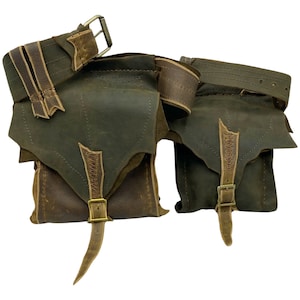 Op de afbeelding: Twee bruine leren buidels met een bruine leren riem. De buidels hebben een klep met een gespsluiting en een lange riem. De riem heeft een gespsluiting.