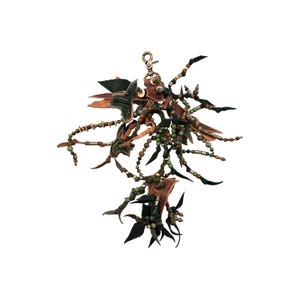 May include: A leather and beaded keychain with a variety of colors, including brown, green, and black. The keychain features a variety of shapes, including stars, circles, and beads.