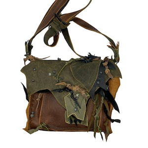 May include: A handcrafted leather shoulder bag in shades of brown and green. The bag features a flap closure and decorative accents, including riveted details, beaded embellishments, and fringed edges. The adjustable strap is brown.