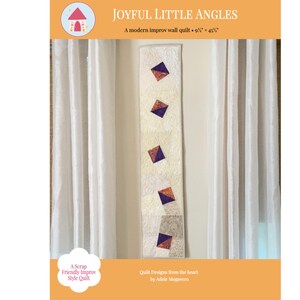 May include: A modern improv wall quilt titled "Joyful Little Angles", measuring 9.5 x 45.5 inches. The quilt features a vertical design with alternating light and patterned fabric sections, adorned with colorful diamond shapes. The text "A Scrap Friendly Improv Style Quilt" is also visible.