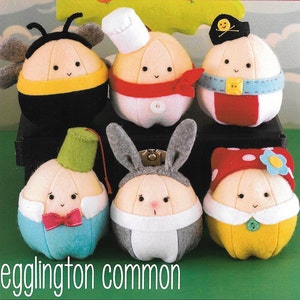 May include: Six plush toys shaped like onions, each wearing a different costume. The costumes include a bee, a chef, a pirate, a bunny, a magician, and a ladybug. The toys are all white with embroidered faces and are made of felt.