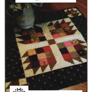 May include: A square fabric quilt topper titled Bear's Candy Topper measuring 27 inches by 27 inches. The quilt features a repeating bear paw block pattern in shades of brown, red, and cream, with a black border and Creek Side Stitches #219 text.