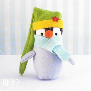 May include: A plush penguin toy wearing a green hat with a yellow band and a red star, a blue scarf, and the word "meep" written below.