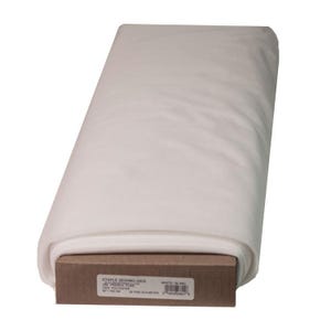 May include: A roll of white fabric, likely tulle, resting on a brown cardboard base. The fabric is tightly rolled and appears soft and lightweight. The label on the base reads "STAPLE SEWING AIDS FRENCH TULLE".