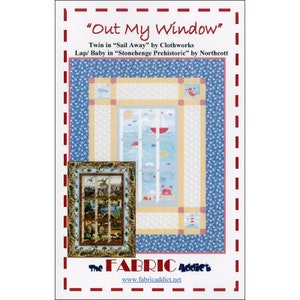 May include: A fabric panel featuring a quilt design with the text "Out My Window". The quilt design includes a window scene with a sailboat, sun, and sea creatures. The panel has a blue and yellow border and a smaller framed image of a different quilt.