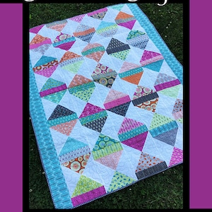 May include: Diamond Daze quilt pattern featuring a colorful diamond design with a white background. The quilt is made with a variety of fabrics in shades of pink, blue, green, orange, and gray. The pattern is by Tricia Lynn Maloney for Villa Rosa Designs.