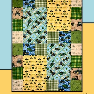 May include: A quilt with a patchwork design featuring a variety of green, yellow, and blue fabrics. The fabric patterns include tractors, plaid, and solid colors. The quilt is labeled "Random Shuffle" and "Molly Cook for Villa Rosa Designs".