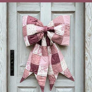 May include: A quilted fabric bow featuring a patchwork design in various shades of pink, white, and mauve. The text reads: THE BIG GIANT QUILTED BOW, Designed to be reversible, Scrappy and fat quarter friendly, 3 style options included, A beginner-friendly sewing pattern + video tutorial by: LGC LINDSEY GRACE CREATES.
