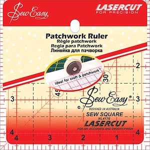 May include: A red and white Sew Easy patchwork ruler with grid lines and measurements. The ruler includes the text "Patchwork Ruler" in multiple languages and "LaserCut for Precision". A rotary cutter is shown in a circular inset.