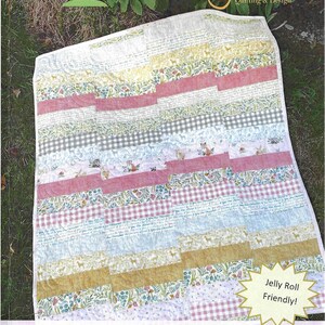 May include: A quilt featuring a patchwork design of horizontal strips in various patterns including floral prints, gingham checks, and woodland animal motifs with foxes and deer. The text on the quilt pattern cover reads A Tricky Path, Jelly Roll Friendly, and Effie's Woods by Deb Strain for Moda.