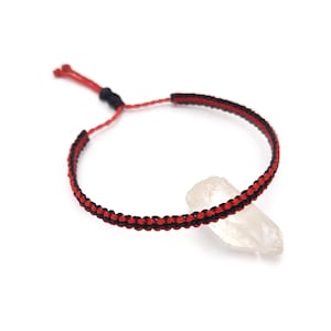 May include: A handmade macrame bracelet with a red and black design. The adjustable bracelet is made of woven cord and features a sliding knot closure. The bracelet is displayed on a white background.