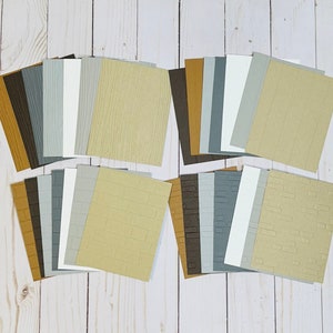 May include: A set of 18 textured cardstock sheets in various colors and patterns, including wood grain, brick, and plain. The sheets are arranged in three rows of six.