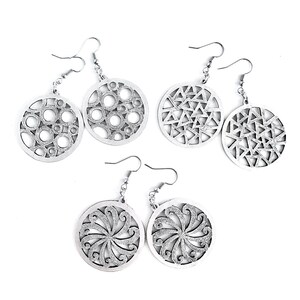 Puede incluir: Conjunto de seis pendientes de plata con diferentes diseños geométricos. Cada pendiente tiene forma circular con un patrón recortado.