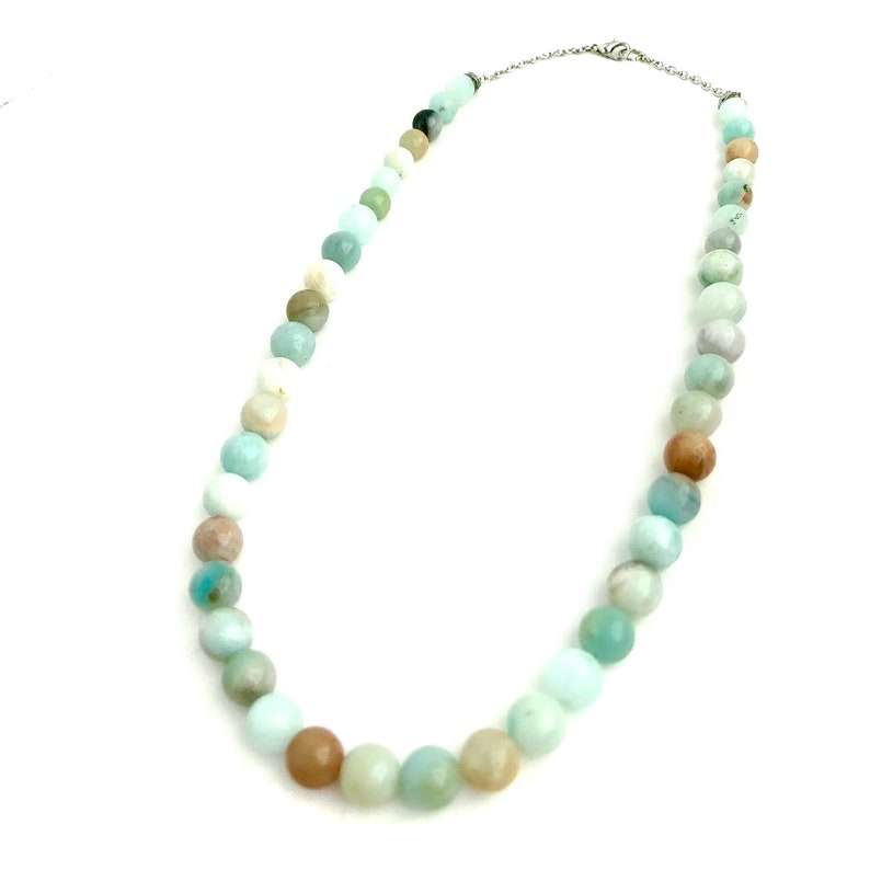 May include: A light blue and brown beaded necklace with a silver clasp.