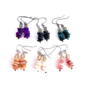 May include: Six pairs of dangle earrings with different colored stone beads. The earrings are made with silver tone metal and feature a variety of colors, including purple, blue, green, and pink.