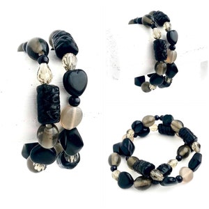 May include: Two black and gray beaded bracelets with various shapes, including hearts, squares, and round beads.