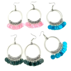 以下が含まれることがあります： 銀製のフープイヤリング3ペア。ぶら下がっているチャームは、小さく、丸く、虹色の素材でできています。イヤリングは、ピンク、ブルー、ターコイズからお選びいただけます。