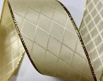 May include: A cream-colored ribbon with a gold trim and a diamond pattern. The ribbon is woven with a subtle texture.